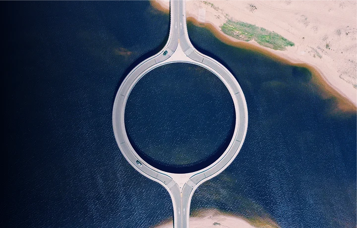 Puente en forma de círculo sobre un río azul.