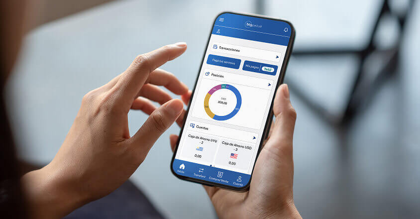 Mano sosteniendo un celular con la aplicación de BTG Pactual