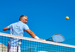 Hombre con camisa azul sosteniendo una raqueta de tenis
