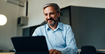Hombre con camisa social usando una notebook